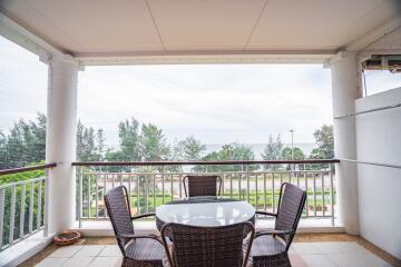 Outdoor balcony with a table and chairs facing a scenic view