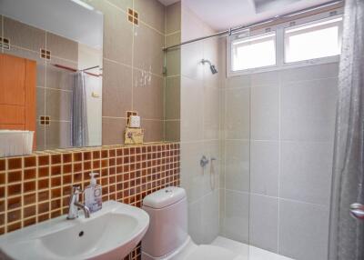 Modern bathroom with a large mirror, sink, toilet, and shower area