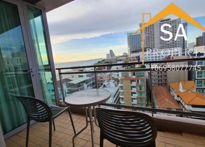 Balcony with a table and chairs overlooking city buildings and partial water view