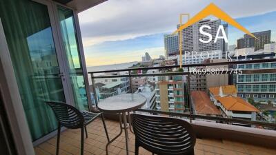 Balcony with a table and chairs overlooking city buildings and partial water view