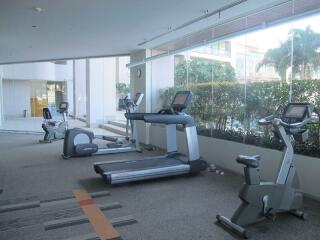 Modern fitness center with cardio equipment and large windows