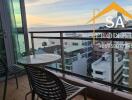 Balcony with chairs and table overlooking city and ocean view