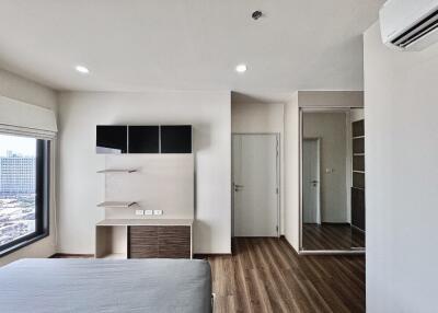 Modern bedroom with large window, shelves, and wooden flooring