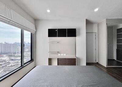 Bedroom with large window and city view