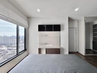 Bedroom with large window and city view