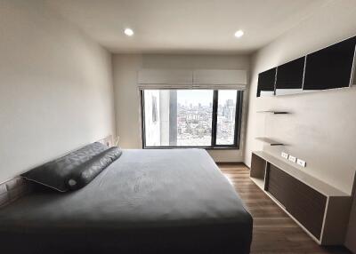 Modern bedroom with a large bed and city view window