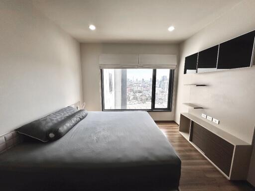 Modern bedroom with a large bed and city view window