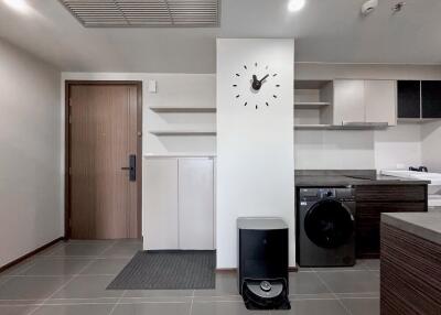 Modern laundry room with washing machine and clock