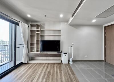 Modern living room with TV, shelf, and balcony view