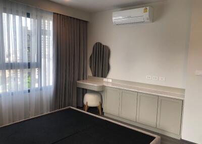 Bedroom with air conditioner, vanity desk, and window