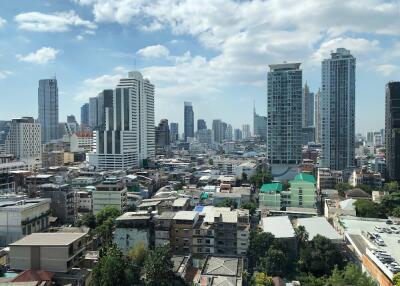 Cityscape with high-rise buildings under a partly cloudy sky