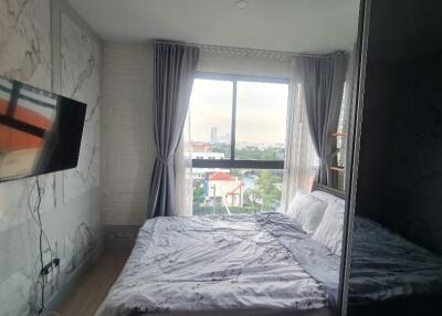 Cozy bedroom with a large window and mounted TV