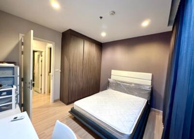 Modern bedroom with wooden flooring, bed, and closet