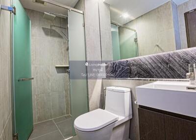 Modern bathroom with glass shower, toilet, and sink