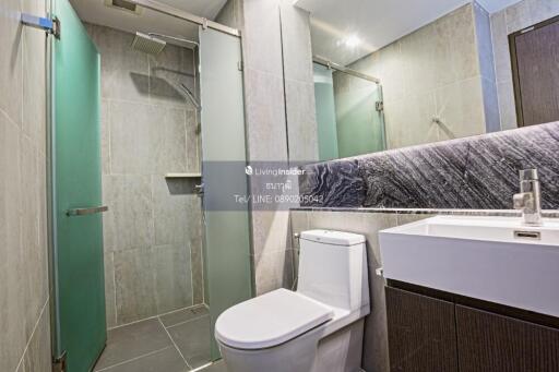 Modern bathroom with glass shower, toilet, and sink