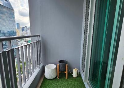 Modern balcony with artificial grass flooring and potted plants