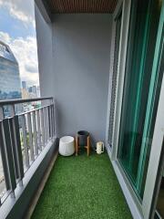 Modern balcony with artificial grass flooring and potted plants