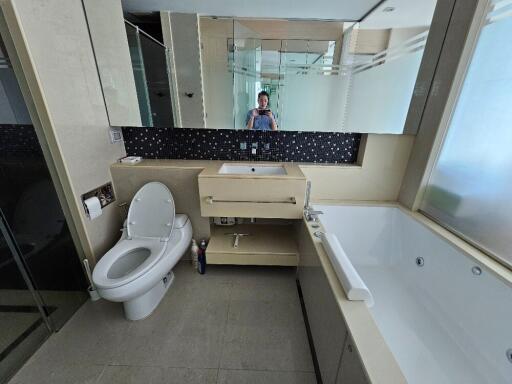 Modern bathroom with large bathtub, sink, and toilet