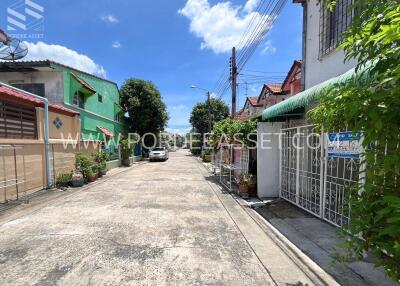 View of a residential street with colorful houses and greenery