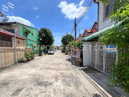 View of a residential street with colorful houses and greenery