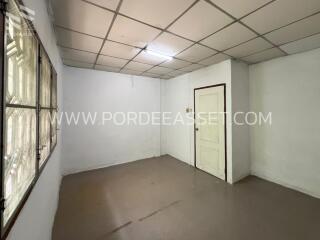 Empty room with tiled ceiling and window