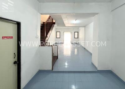 Spacious empty room with staircase and door