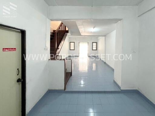 Spacious empty room with staircase and door