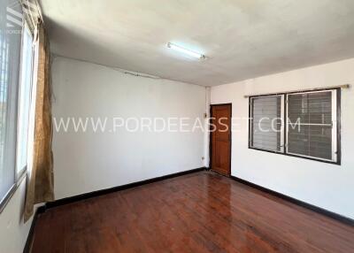 Empty bedroom with wooden floor and windows