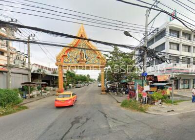 Street view with an ornate archway and a yellow taxi