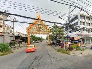 Street view with an ornate archway and a yellow taxi