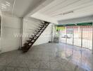 Spacious living room with tiled floor and modern staircase