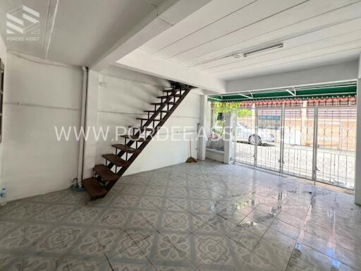 Spacious living room with tiled floor and modern staircase