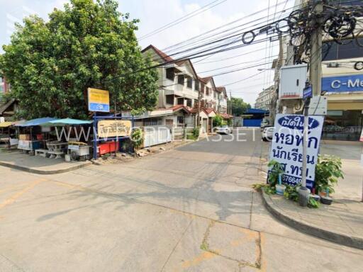 Street view of a neighborhood with buildings and small shops