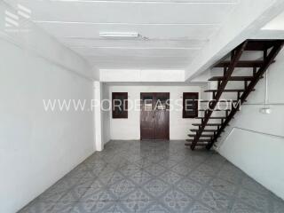 Living space with stairs, tile flooring, and windows