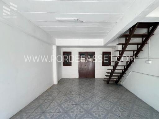 Living space with stairs, tile flooring, and windows