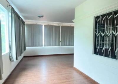 Spacious living room with large windows and wooden floor