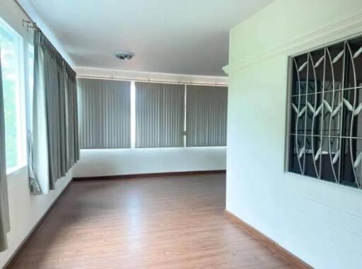 Spacious living room with large windows and wooden floor