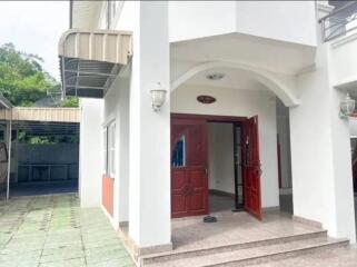 Front view of a modern house with an open red door