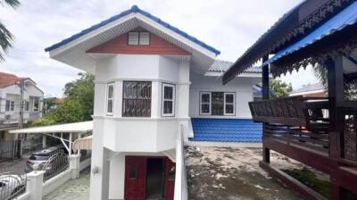 exterior view of a two-story house with unique architectural design and covered seating area