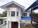 exterior view of a two-story house with unique architectural design and covered seating area