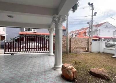 Covered outdoor patio with ornate columns and gate view