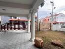 Covered outdoor patio with ornate columns and gate view