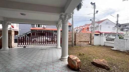 Covered outdoor patio with ornate columns and gate view