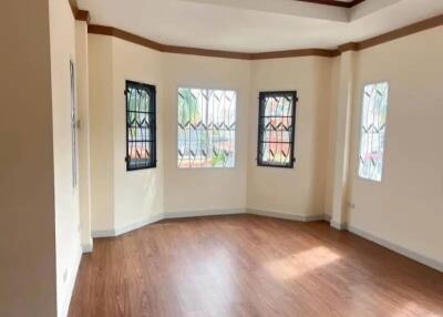 Spacious living room with large windows and wooden flooring