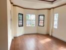 Spacious living room with large windows and wooden flooring