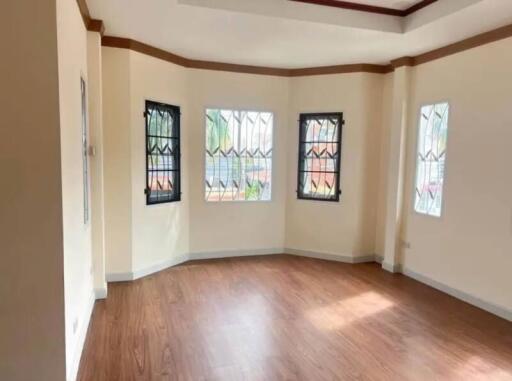 Spacious living room with large windows and wooden flooring