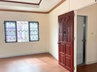 Empty bedroom with wooden door and windows with grills