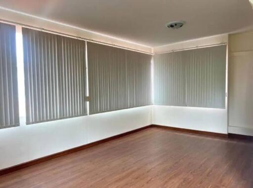 Spacious room with large windows and vertical blinds