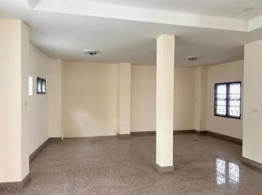 Spacious living room with large pillars and tiled flooring