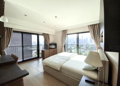 Spacious bedroom with large windows offering city views